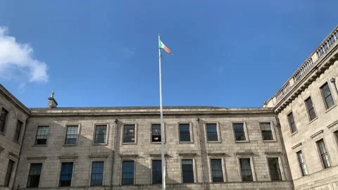 Irish Flag on a pole. Four Courts building in the background. Dublin, Ireland Stock Footage 252430846