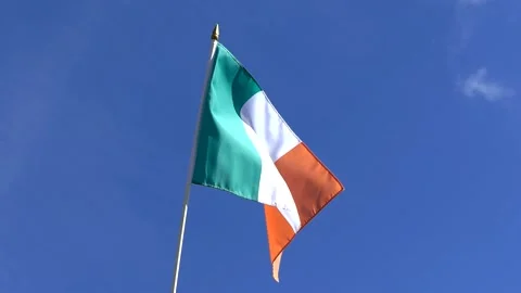 The Irish flag waving in the wind in the blue sky Stock Footage 282432726