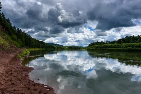 Irkut river with a quiet current and clouds reflection, Eastern Siberia, Russia Stock Photos