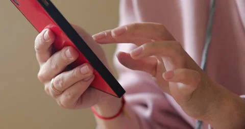 Irl's hands click on the screen of the smartphone Red phone Pink jacket Stock Footage 132069705