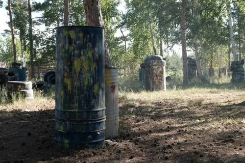 Iron barrels in the foreground with multi-colored blots and smudges from shot Stock Photos