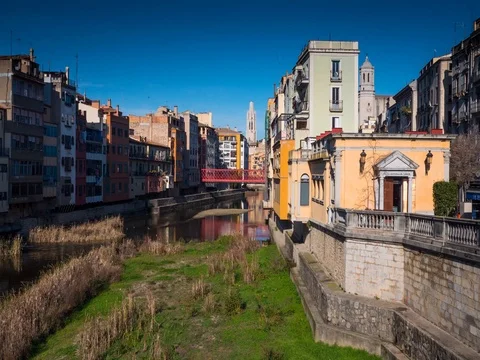Iron Bridge of Eiffel across river Onyar and colorful yellow and orange houses Stock Footage 75577328