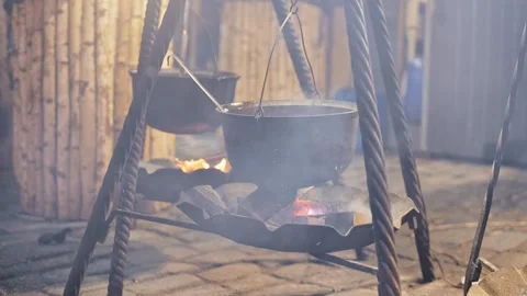 Iron cauldron hanging over fire with smoke rising at Old Riga Christmas market Vídeo Stock 317106285