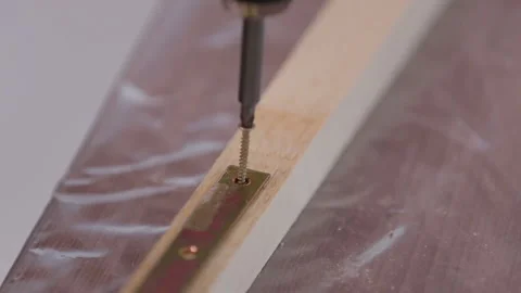 Iron corner fixed with a self-tapping screw to the rail, close-up Stock Footage 95528076