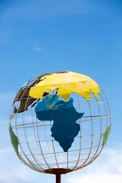 Iron earth globe structure with blue sky and African continent Stock Photos