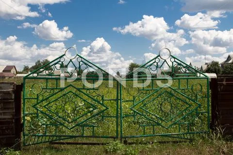 Iron fence and a blue sky with clouds Stock Photos