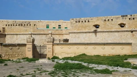 Iron gate opens into a fort st elmo courtyard limestone walls enclosing the Stock Footage 341806424