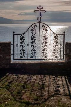 An iron gate ornamented with religious elements. Stock Photos