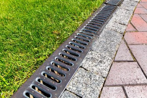 Iron grate of a drainage system for storm water drainage. Stock Photos