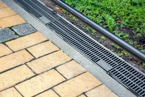 Iron grating of the drainage system for drainage of rainwater. Stock Photos