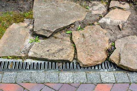 Iron grating line of the drainage system of the pedestrian sidewalk. Stock Photos