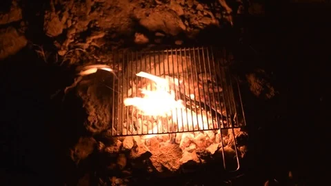 Iron grill is heating on campfire at night on a windy weather Stock Footage 77845698