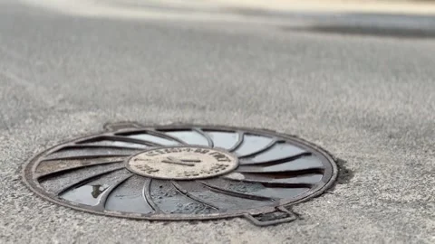 A iron hatch with a pattern above an observation well is located on auto road in Видео 300052840