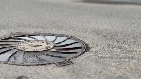 A iron hatch with a pattern above an observation well is located on auto road in Stock Footage 300217633