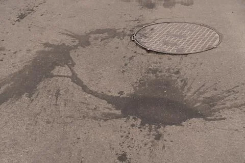 A iron hatch with a pattern above an observation well is located on auto road in Stock Photos