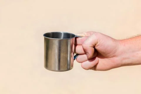 Iron mug in hand Stock Photos
