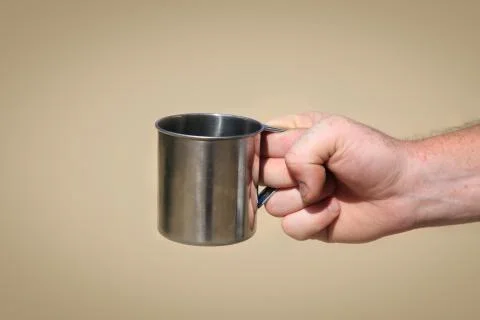Iron mug in hand Stock Photos