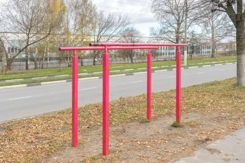 Iron parallel bars with peeling red paint for pulling up are installed next t Stock Photos