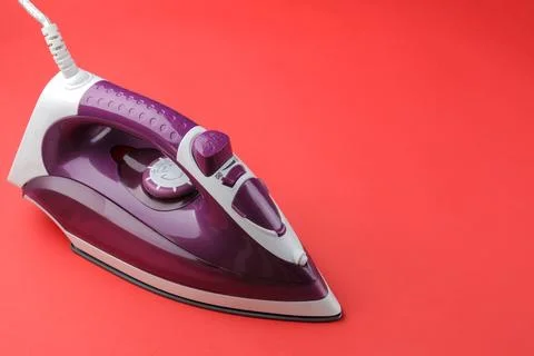 Iron on a red background. space for text Stock Photos