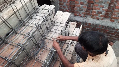 Iron rod framework being laid down on wooden shuttering for casting RCC stairs Stock Footage 201622324