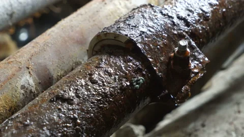 Iron rusty pipes leaking in basement of old house water drops on repair clamp Video stock 111403036