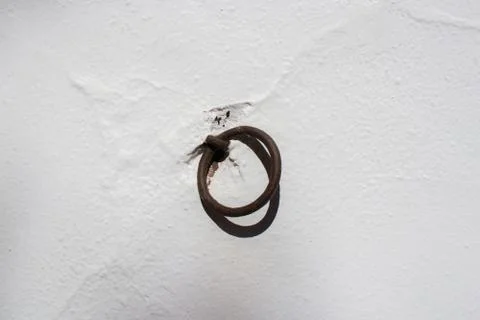 An iron rusty ring is suspended on a  wall. Stock Photos