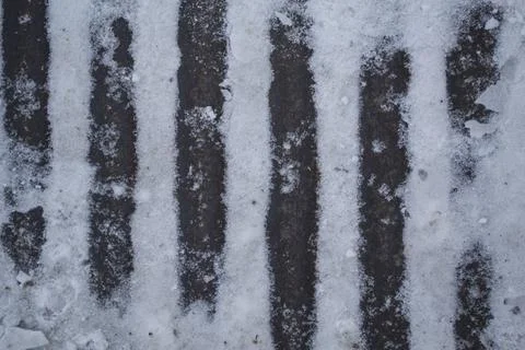 Iron stripes show through the snow. Stock Photos