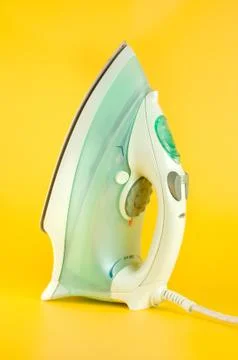 Iron on a yellow background Stock Photos