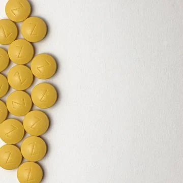 Iron in yellow tablets on a white background Stock Photos