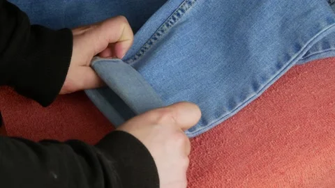 Ironing blue jeans.Steaming function in an electric appliance. Stock Footage 144445726