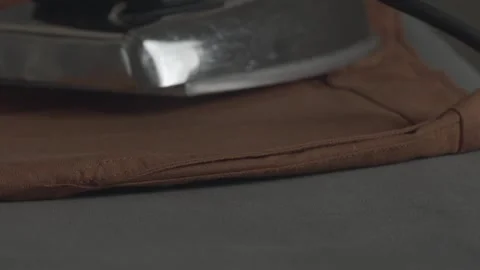 Ironing clothes - isolated close up in a dark sweatshop Stock Footage 260282026