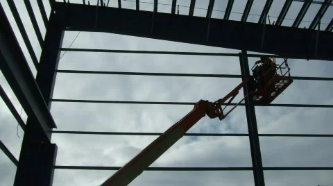 Ironworker erecting structure with aide of crane Stock Footage 299874