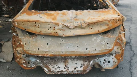 Irpin, April 2022, burnt in a shelled car in a parking lot. War in Ukraine Stock Footage
