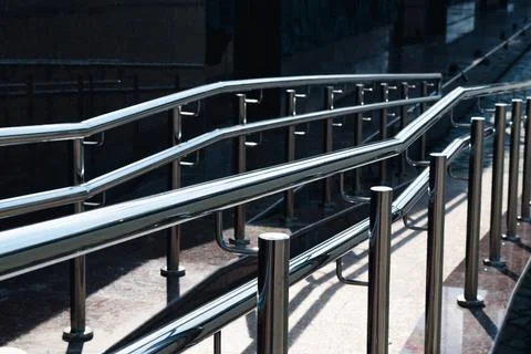 Irregular chrome ramp railing with bright highlights Stock Photos