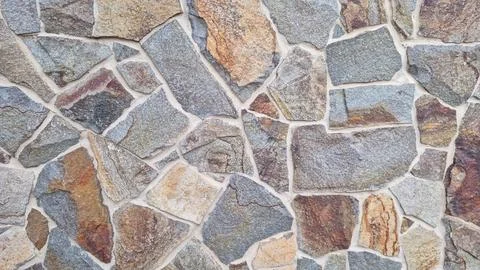 Irregular natural stone wall texture with multicolored rough granite Stock Photos