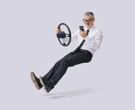 Irresponsible businessman using a smartphone while driving an invisible car Stock Photos