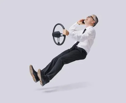 Irresponsible businessman using a smartphone while driving an invisible car Stock Photos