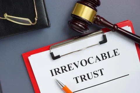 Irrevocable trust document on the clipboard and gavel. Stock Photos