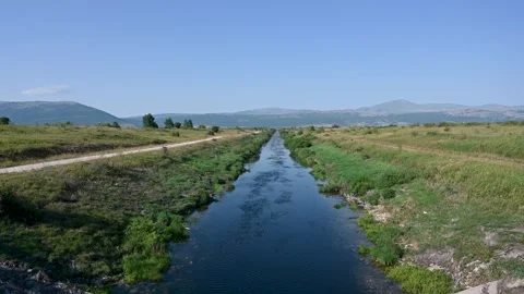 Irrigation channel in the field. The river flows in nature Stock Footage 309951186