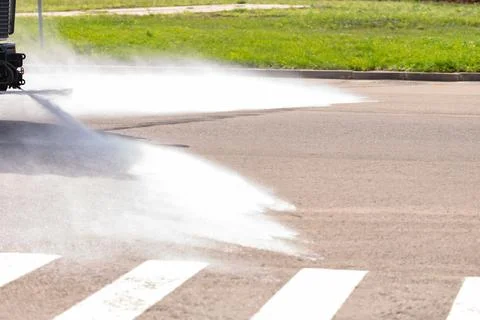 The irrigation machine washes the asphalt Stock Photos
