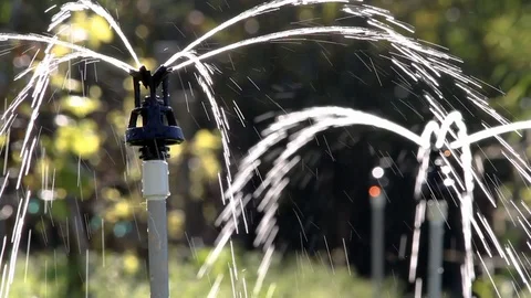 Irrigation System Starts Spreading Clear Water on Summer Day Stock Footage 110333178