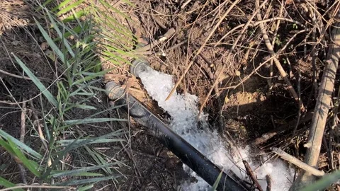 Irrigation Water Flowing from a Plastic Pipe into a Rural Farm Field 스톡 동영상 325064664