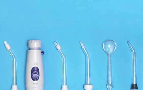 Irrigator and replaceable nozzles on a blue background with copy space. Good Stock Photos