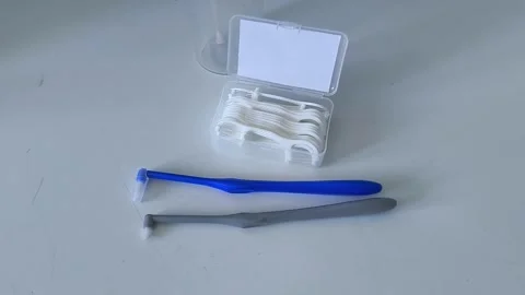 An irrigator, a toothbrush, a container of dental floss, flossers on the table Stock-Footage 329969422