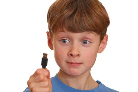 Irritated boy looks at a USB jack Stock Photos
