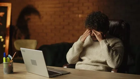 Irritated curly man beating table with his fist while working with laptop Stock Footage 231475632