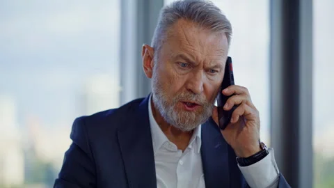 Irritated director talking cellphone sitting office closeup. Senior manager Stock Footage 319964788