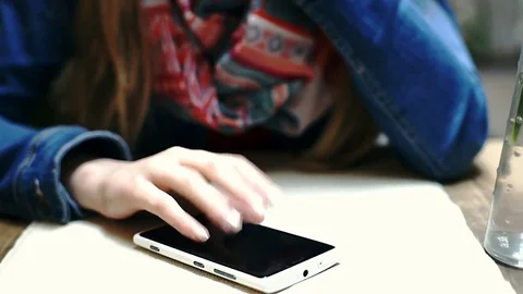 Irritated girl tapping on smartphone's screen while waiting for someone Stock Footage