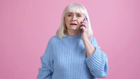 Irritated granny argue unknown scammers device isolated pastel color background Stock Footage 170201162