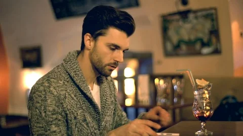 Irritated man waiting for someone in a pub and checking time Stock-Footage 70126481